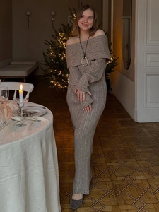 Elegant off-shoulder coffee brown knitted maxi dress shown in a cozy festive holiday setting