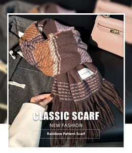Close-up of thick plaid scarf in brown and purple with long fringe and white woven label