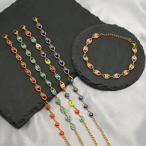 Detailed macro view of gold evil eye bracelets in multiple colors on a black stone tray