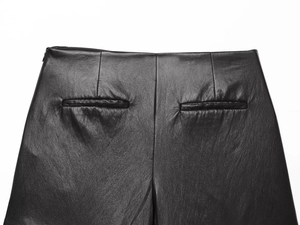 Détail de la jupe-culotte en similicuir noir avec poches passepoilées au dos et taille