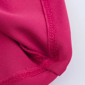 Macro della texture in maglia rosso rosa e delle cuciture fini dell'abito lungo