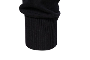 Detail of black knitted cotton sweater showing ribbed cuffs and elastic fabric texture