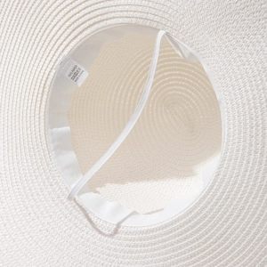 Detail of white paper straw hat interior with sweatband and elastic chin strap
