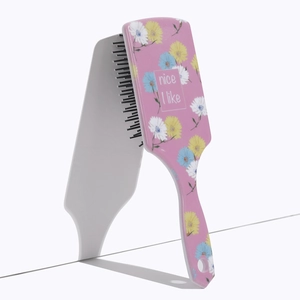 Detailed view of pink square hairbrush with floral pattern and nice I like print