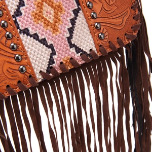 Detailed macro view of bohemian embossed leather bag with ethnic weaving and long fringes