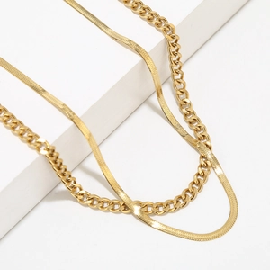 Detail of layered 18K gold-plated stainless steel snake and Cuban chain necklaces
