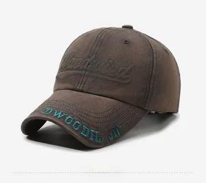 Detail of dark brown washed cotton baseball cap with cyan 3D letter embroidery