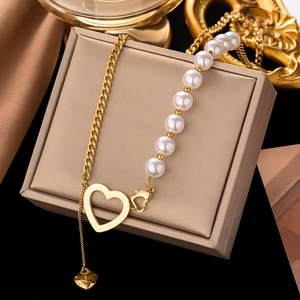 Collier chic avec pendentif cœur, chaîne gourmette dorée et détails en perles blanches
