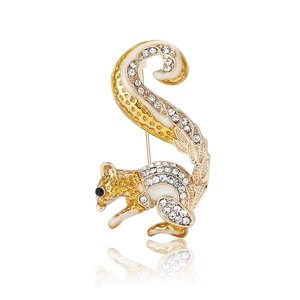 Golden squirrel brooch with sparkling rhinestones and white enamel on a white background