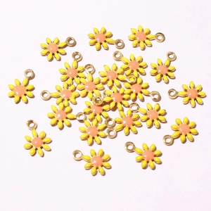 Macro detail of daisy flower charms with yellow petals and gold-plated rings