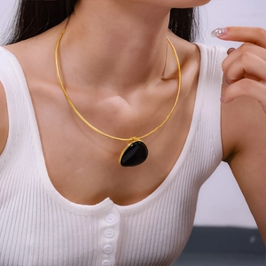 British vintage gold snake chain necklace with black onyx teardrop pendant on a model