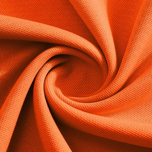 Detailed macro view of orange pique mesh fabric texture on men's polo shirt