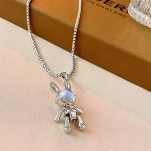 Detail shot of a silver rabbit astronaut necklace with blue marble stone and box chain