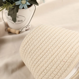 Close-up of woven cotton rope texture on a cream shell-shaped crossbody beach bag