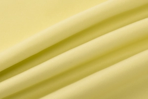 Primo piano del tessuto a maglia giallo chiaro con texture dettagliata e motivi a coste