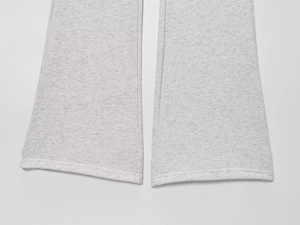 Detail of flared cuffs on grey heather knitted trousers featuring smooth marl texture