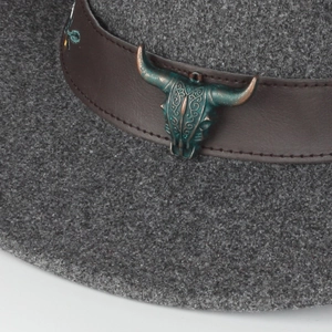 Detailed close-up of dark grey fedora featuring a vintage bronze bull head on leather band