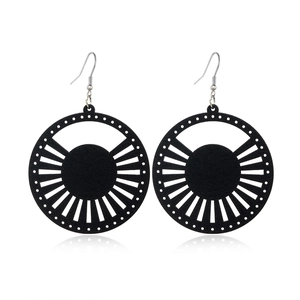 Detail of black hollow wood earrings with creative geometric sunburst pattern