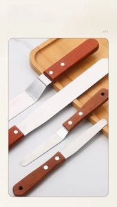 Detailed set of stainless steel spatulas with mahogany handles for cake decorating
