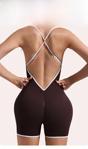 Detail of cross-back straps with metal buckles on brown ribbed yoga bodysuit