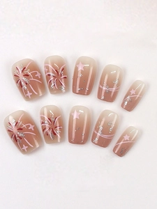 Detail of short almond press-on nails with pink fireworks and star glitter patterns