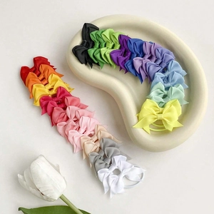 Dettaglio di elastici per capelli fatti a mano con fiocchi in grosgrain multicolore