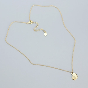 Detail of 925 sterling silver S925 hallmark on heart tag and gold shell pendant