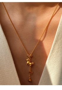 Close-up of a 24K gold-plated pony pendant necklace worn on a woman's neck