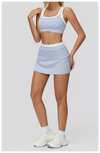 Detail of light blue yoga set featuring white contrast trim on sports bra and skirt