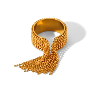 Macro shot of gold tassel ring with small beads and fluid metallic fringe details