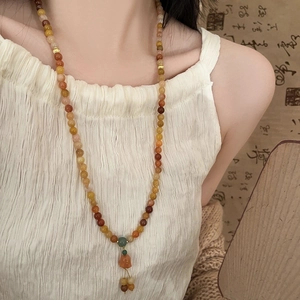 Multi-strand lily-of-the-valley crystal bead necklace in warm amber and red tones