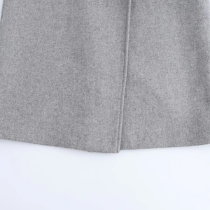 Macro shot of grey wool coat hemline showing high-quality fabric texture and stitching