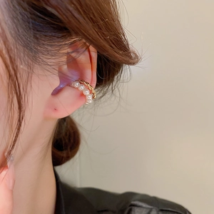 Close-up of a gold-plated double-layer ear cuff with pearls worn on the ear bone