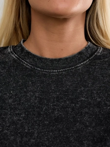 Close-up of the vintage washed dark grey crew neck and distressed texture on cotton T-shirt