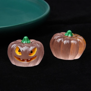 Glow-in-the-dark pink resin Halloween pumpkins with carved face and green stem detail