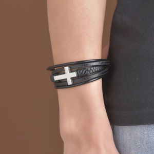 Détail d'un bracelet multicouche en cuir noir pour homme avec breloque croix en métal