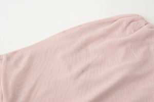 Close-up detail of pink mesh fabric texture on an off-shoulder ruffled sweet blouse