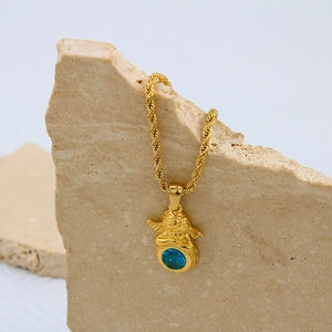 Vue détaillée du pendentif ange doré vintage avec une pierre précieuse bleue éclatante