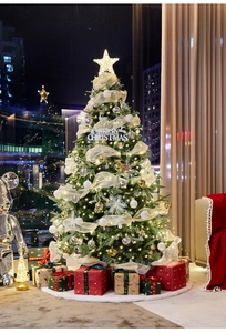 Detail of Christmas tree with LED lights, gold ornaments, and plush white tree skirt