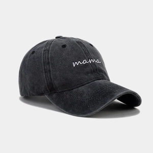 Close-up of white mama embroidery on a washed charcoal grey cotton baseball cap