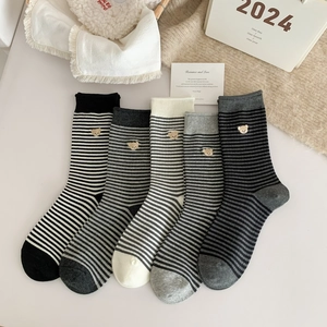 Close-up of five pairs of striped knit socks with cute bear embroidery and ribbed texture