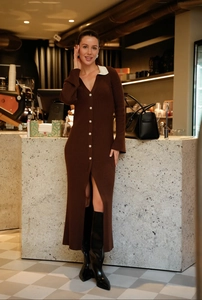 Détail d'une robe en tricot marron moulante avec col polo contrasté et boutons perlés