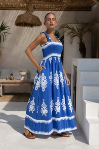 Detail of blue boho maxi dress featuring a shirred bodice and white floral patterns