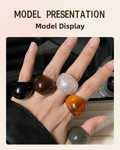 Detailed close-up of chunky resin rings in multiple colors on a model's hand