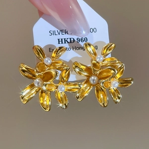 Detailed close-up of vintage flower earrings with pearls and gold-plated floral petals