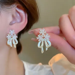 14k gold plated flower stud earrings with zircon crystals and white ribbon bows