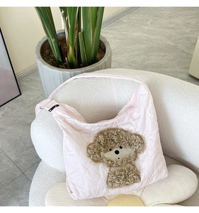 Detail of pink quilted fabric tote with cute brown plush teddy bear embroidery design
