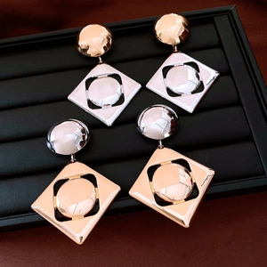 Detail view of geometric round and rhombus earrings in gold and silver mixed metal finish
