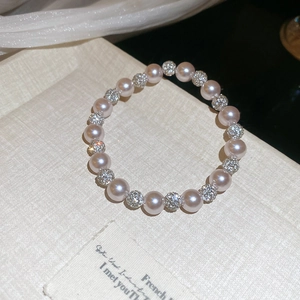 Detail of pink pearl necklace with crystal-encrusted beads on French book cover