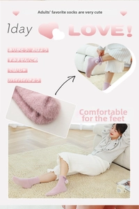 Detailed view of pink plush winter socks with cute purple bow and pompom accents